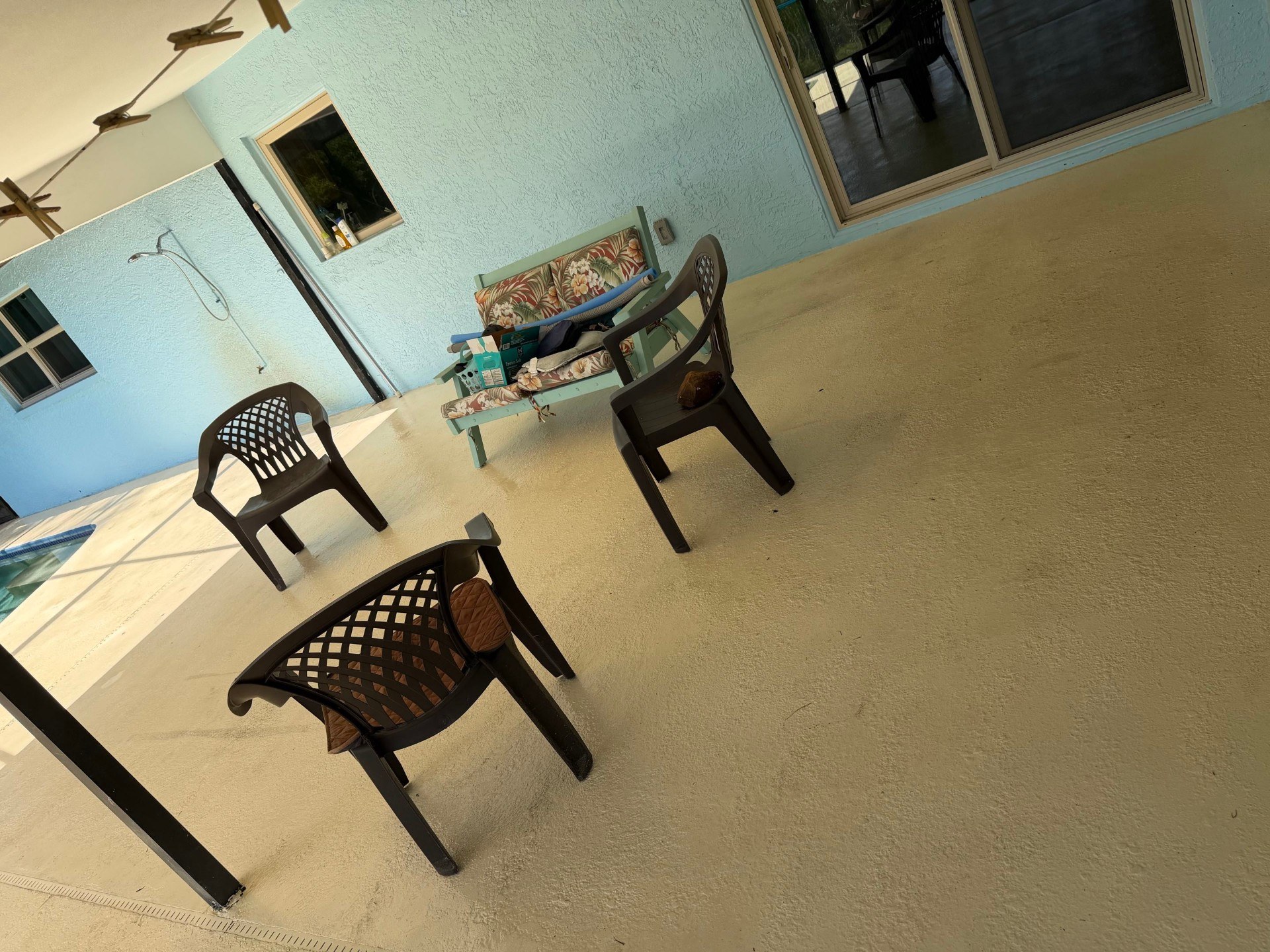 Dirty screened pool patio pressure washed back to clean concrete — after